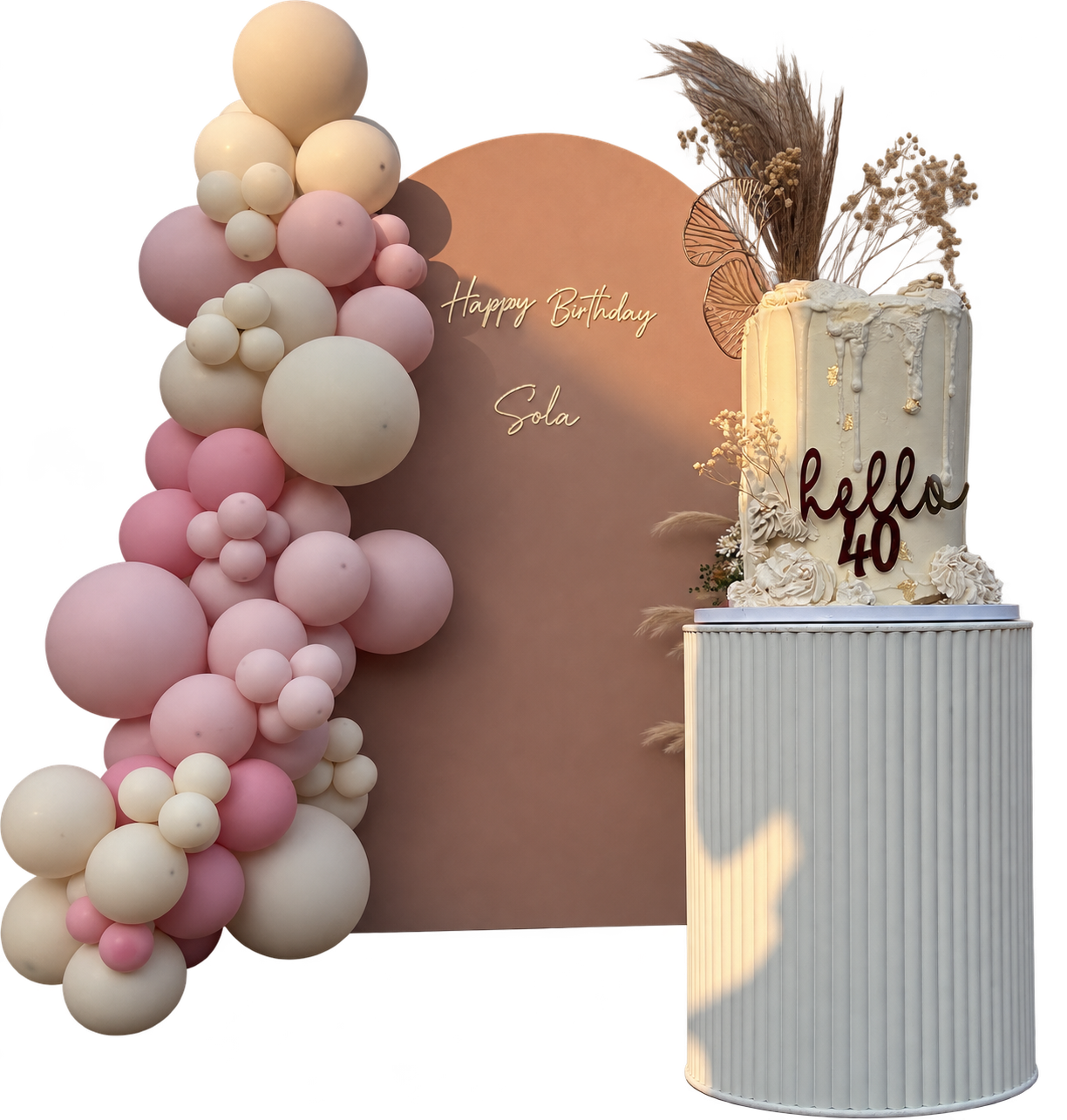 Blush, cream and terracotta balloon garland with an arched backdrop and tiered birthday cake